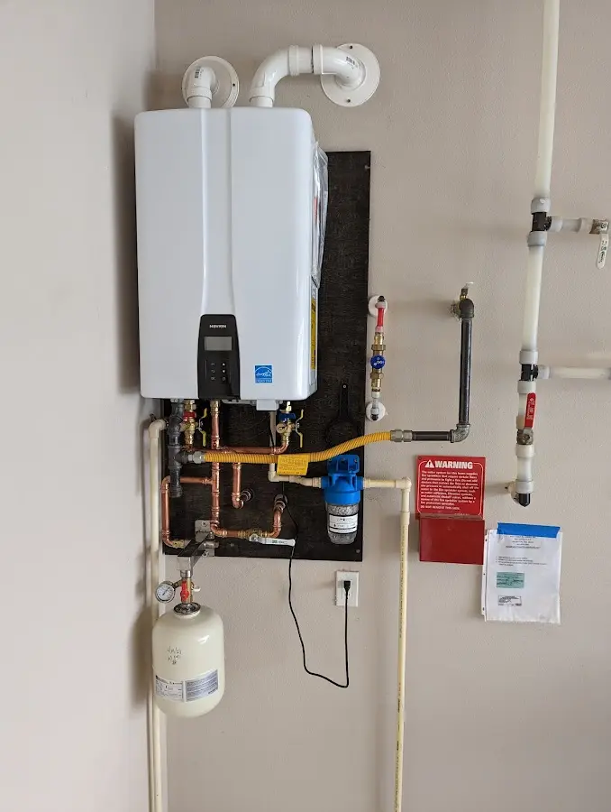 Professional plumber installing copper piping in a Burke Centre home